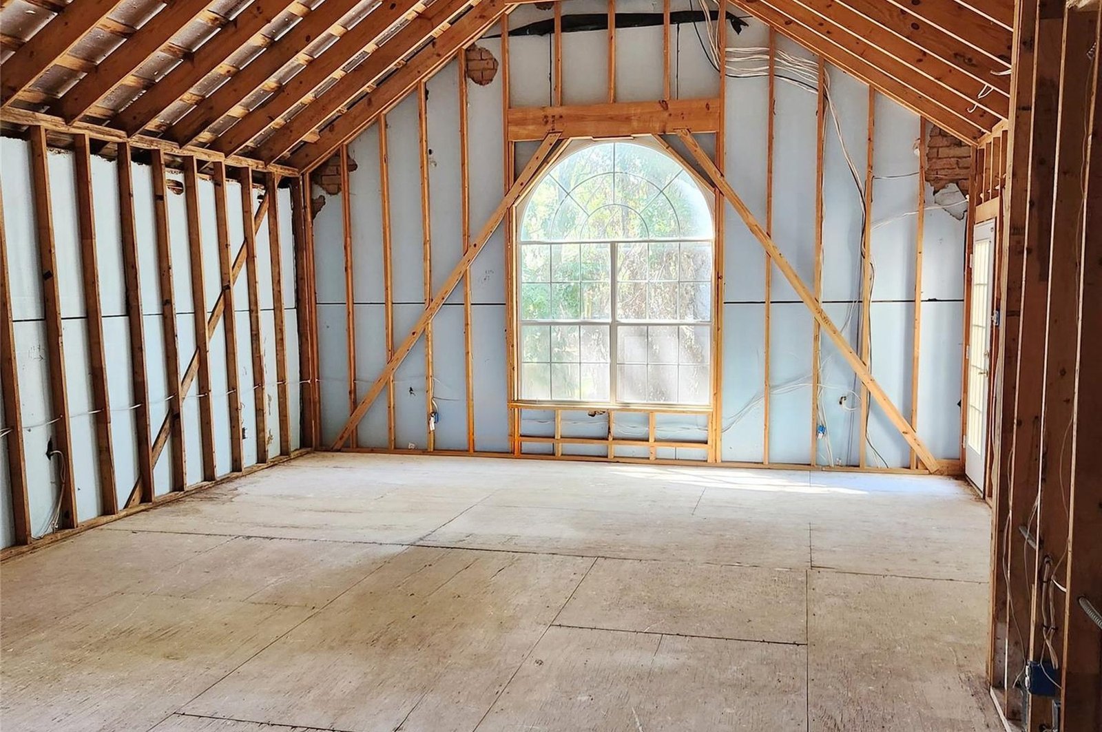 Vaulted living and dining room framed to studs during renovation in McKinney, TX