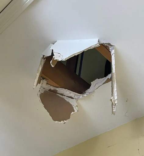 Hole punched through drywall on a ceiling