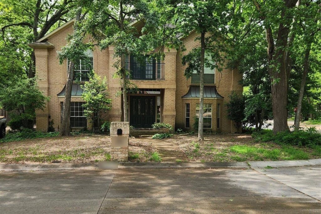 Two-story tan brick home before exterior painting